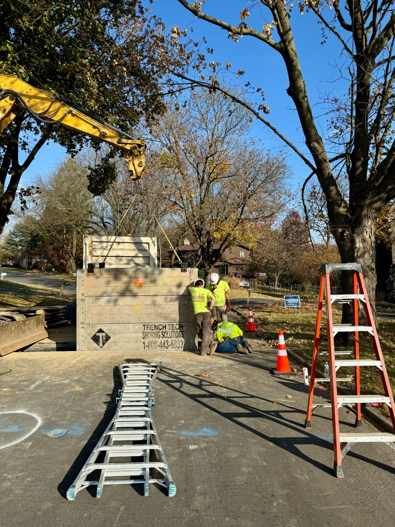 Crew installing trench shoring with excavator on a utility excavation site