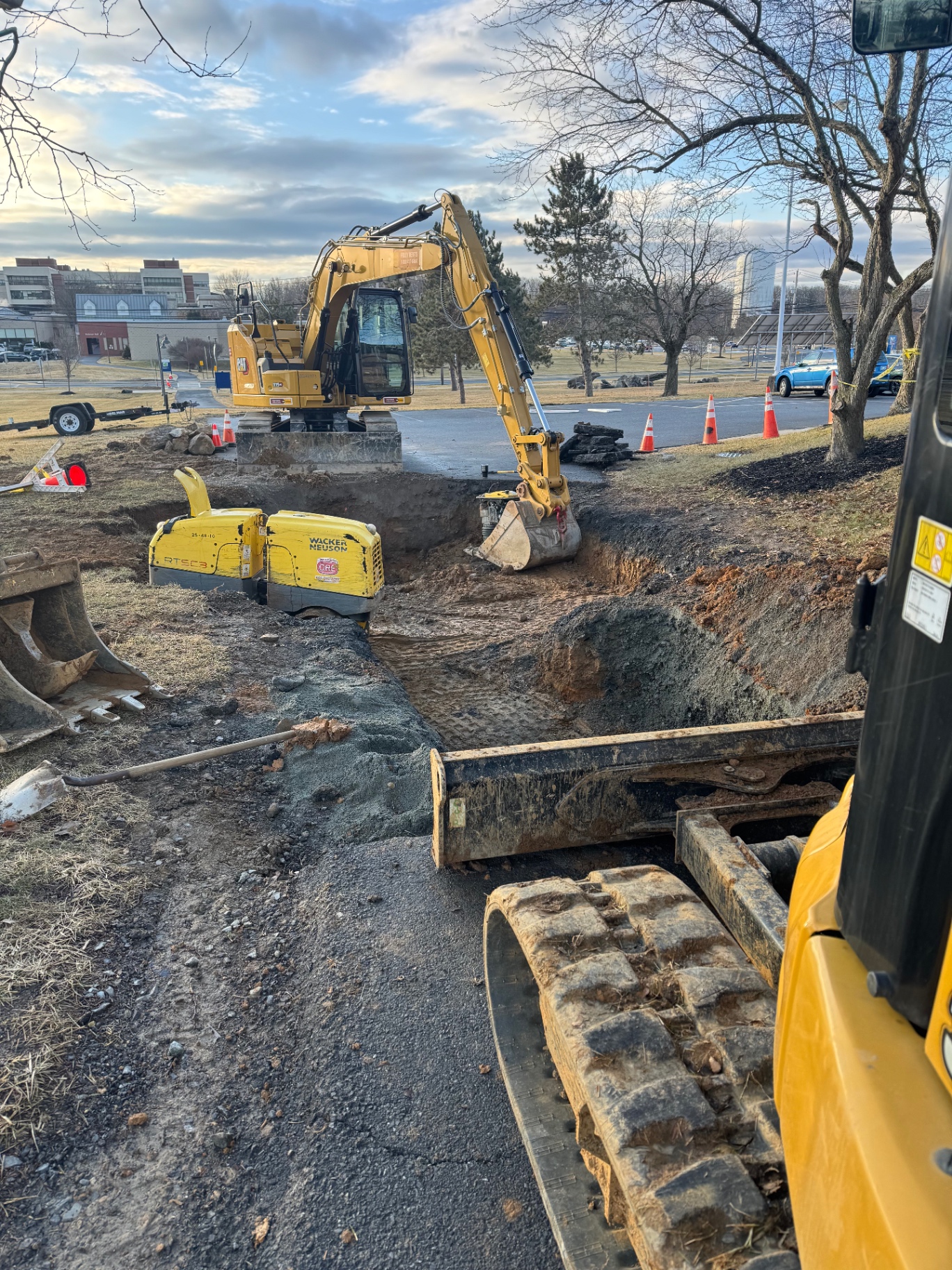 Excavator performing sinkhole remediation and emergency waterline repair