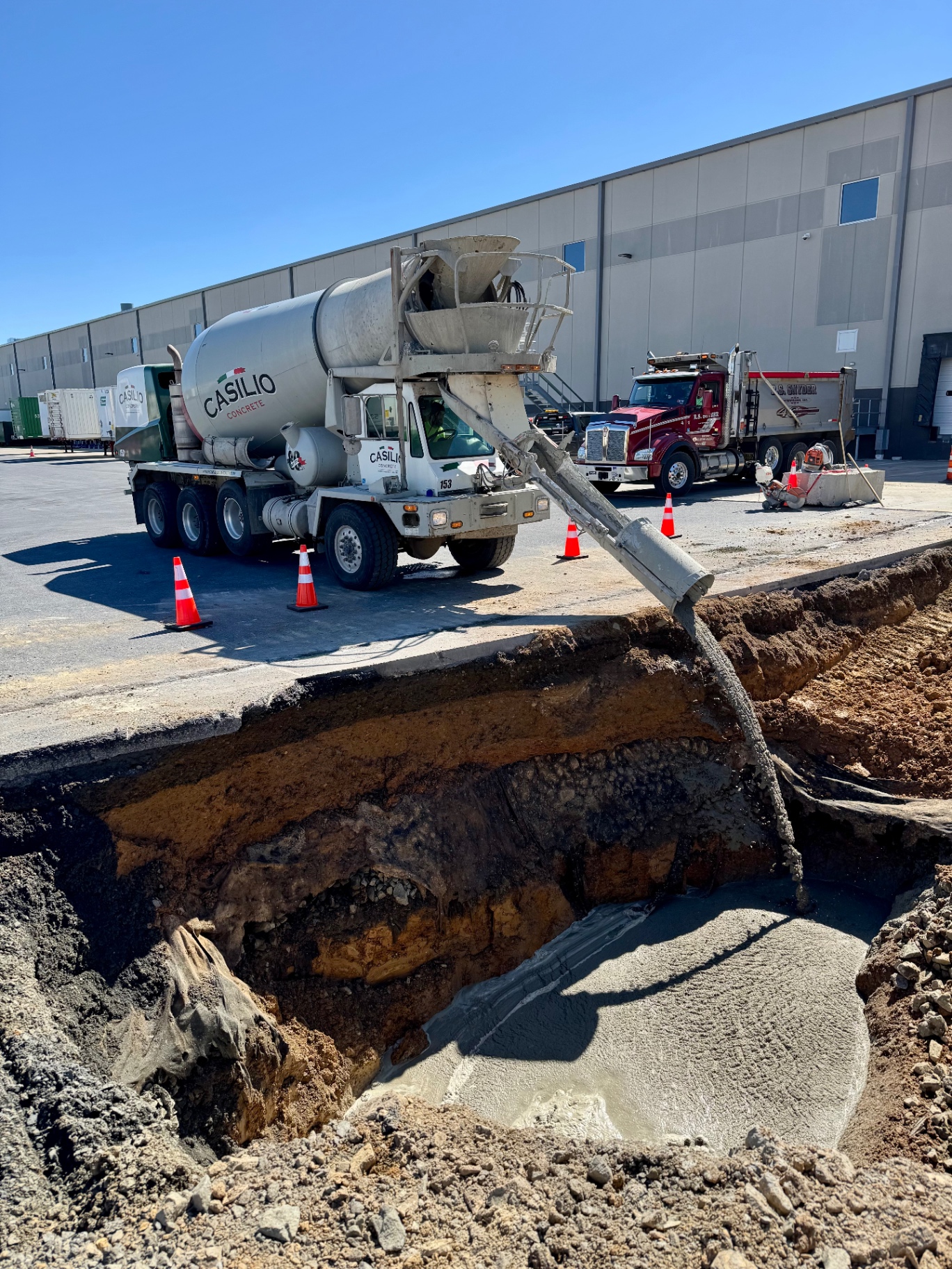 Concrete truck pouring material into a commercial utility trench