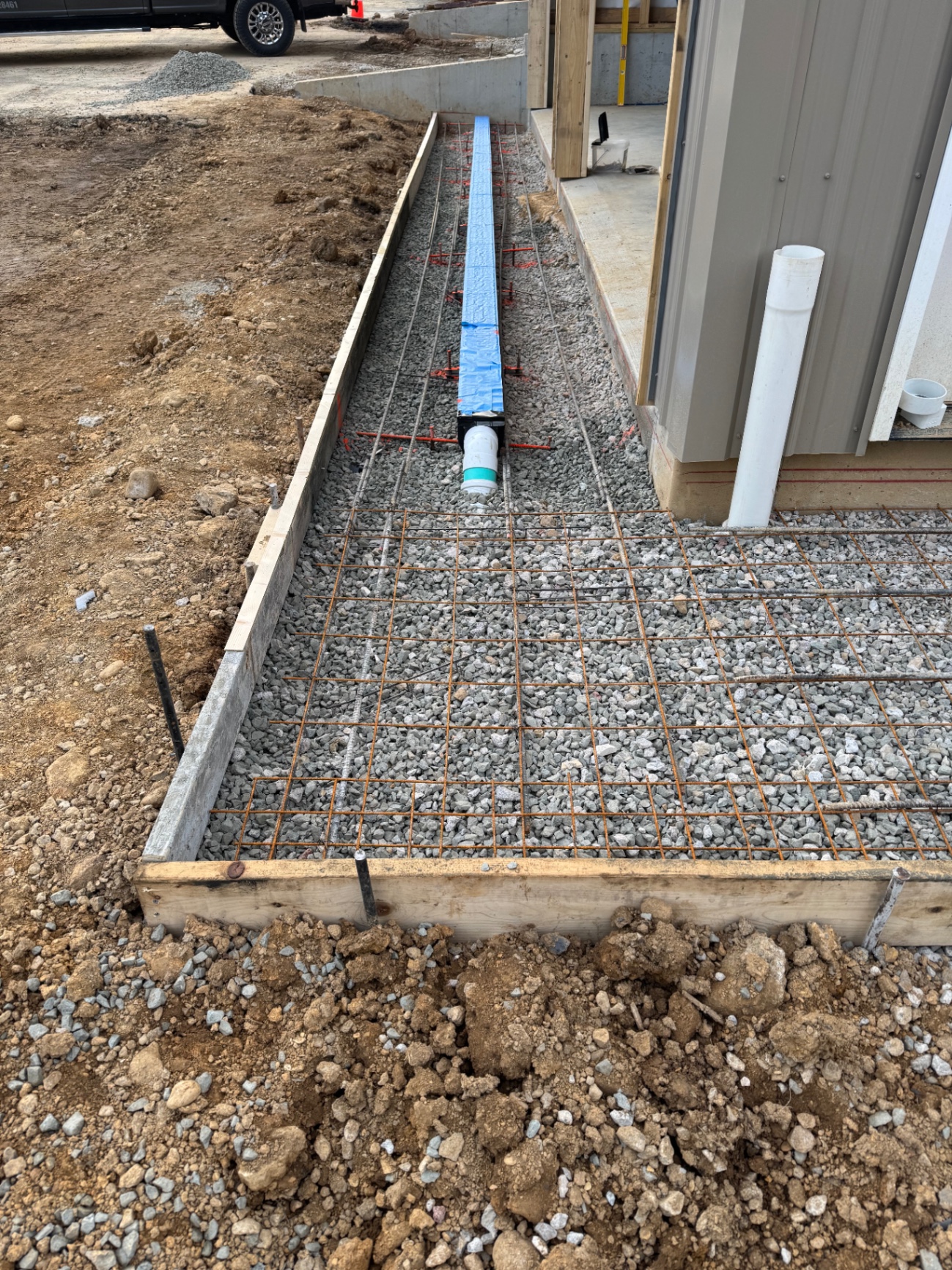 Prepared base and utility work beside a commercial building